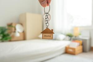 Moving house, relocation. The key was inserted into the door of the new house, inside the room was a cardboard box containing personal belongings and furniture. move in the apartment, banner photo