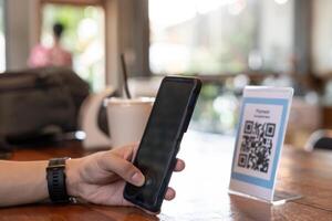 hombre utilizar teléfono inteligente a escanear qr código para orden menú en café restaurante con un digital entrega. escoger menú y orden acumular descuento. mi billetera, tecnología, pagar en línea, crédito tarjeta, banco aplicación foto