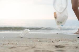 Save water. Volunteer pick up trash garbage at the beach and plastic bottles are difficult decompose prevent harm aquatic life. Earth, Environment, Greening planet, reduce global warming, Save world photo