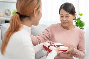 Mother day, cute asian teen girl give gift box to mature middle age mum. Love, kiss, care, happy smile enjoy family time. celebrating special occasion, happy birthday, happy new years, merry Christmas photo