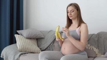 equilibrato dieta e peso monitoraggio di un' incinta donna. calcio come un' necessario tracciare elemento per fetale sviluppo. incinta donna mangia Banana e frutta video