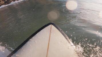 surfista em prancha de surfe equitação em uma quebra aceno. primeira pessoa Visão do surfar dentro oceano às nascer do sol video