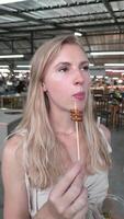 Young woman eating fried insects at a night market in Phuket. video