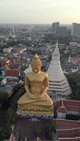 gigante dourado Buda às pôr do sol com uma lindo cidade Horizonte dentro a fundo. video