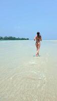 jovem mulher corrida em uma tropical paraíso de praia dentro lento movimento. video