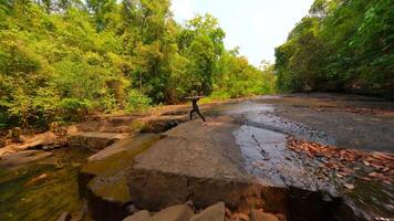 fpv van vrouw praktijken yoga door de rivier- in tropisch regenwoud, Thailand video