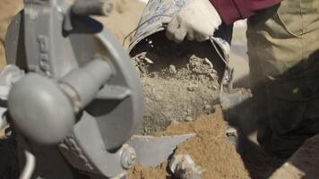 Construction worker pouring cement into mortar mixing machine video