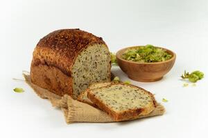 orgánico un pan de todo grano harina y salto de masa fermentada. seco salto flores en de madera cuenco y hecho en casa un pan. arte panadería concepto foto