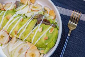 Salad with avocado serving on white plate photo