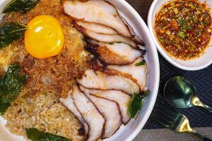 fried rice with Thai basil and grilled belly pork on top with fried egg - Thai food photo