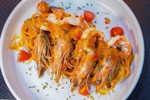 Spicy spaghetti with shrimps in tomato sauce close-up on a plate. top view from above photo