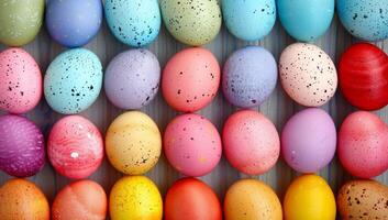 ai generado vistoso Pascua de Resurrección huevos en un fila, vibrante pastel paleta con moteado patrones foto