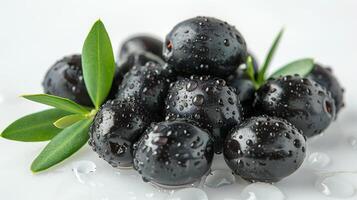 ai generado Tres negro aceitunas con verde hojas en un plata superficie foto