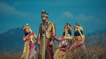 traditionell asiatisch Familie im zeremoniell Kleidung gegen ein bergig Hintergrund. video