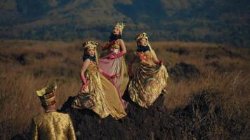 Traditional dancers in ornate costumes performing in a natural landscape video