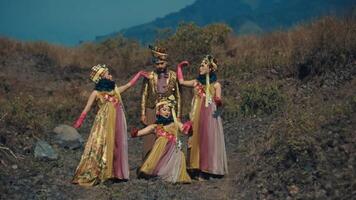 traditionnel danseurs dans fleuri costumes performant en plein air avec une montagneux toile de fond. video