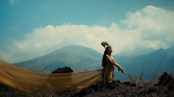 Adventurous hiker setting up a tent with scenic mountain backdrop under a clear sky. video