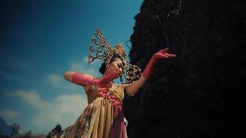 tradicional balinés bailarín en disfraz ejecutando al aire libre con un dramático cielo antecedentes. video