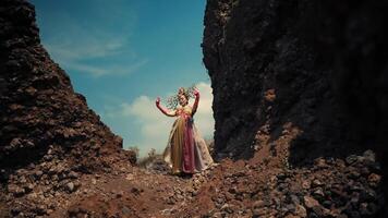 Elegant woman in a vintage dress walking between rocky cliffs under a clear sky, evoking a sense of adventure and timelessness. video