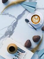 Flat lay background for product placement with paper planes, coffee, book and pinecones photo