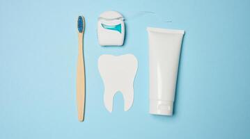 Toothpaste and dental floss on a blue background photo