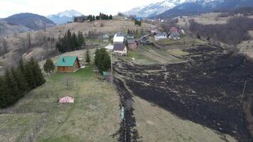 bruciato campo Il prossimo per case. buio terra causato di fuoco. foresta fuoco. Pericolo di fuoco vicino case. video