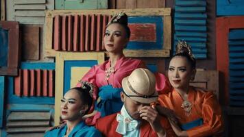 Stylish group of people posing in front of a colorful wooden pallet background. video