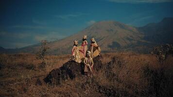 traditionell Stammes- Frauen Gehen im ein Linie im ein robust Landschaft mit ein Berg im das Hintergrund. video