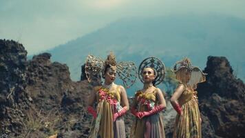 Two women in traditional costumes posing with a mountainous backdrop. video