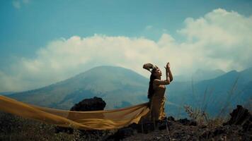 Silhouette of a person with flowing fabric against a mountainous backdrop, evoking a sense of freedom and adventure. video