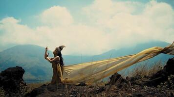 Woman in flowing dress with mountains in background, evoking a sense of freedom and elegance. video