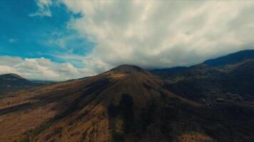 aéreo Visão do uma majestoso montanha debaixo uma dramático céu com varrendo nuvens. video