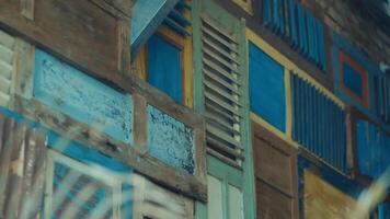 Colorful wooden shutters on a rustic house facade, depicting weathered textures and vintage architectural details. video