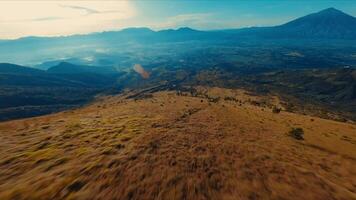 aérien vue de une vaste, vallonné paysage avec clairsemé végétation en dessous de une clair ciel. video