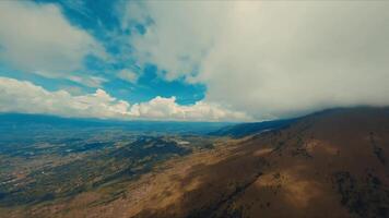 aereo Visualizza di un' vasto paesaggio con rotolamento colline sotto un' blu cielo con sparpagliato nuvole. video