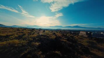 panoramico aereo Visualizza di un' lussureggiante verde valle con rustico edifici e montagne video