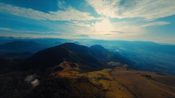 Aerial view of rolling hills under a blue sky with wispy clouds. video