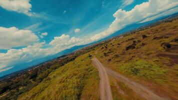 szenisch Landschaft mit ein Schmutz Pfad führen durch ein grasig Feld unter ein Blau Himmel mit flauschige Wolken. video