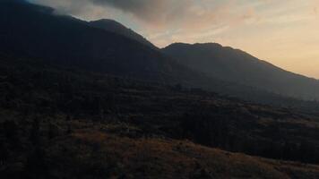 majestoso montanha panorama às crepúsculo com suave luz e sombras, transmitindo uma sereno e tranquilo atmosfera. video