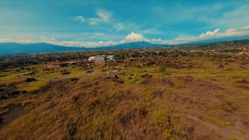 Aerial view of a rugged volcanic landscape with lush greenery under a clear sky. video