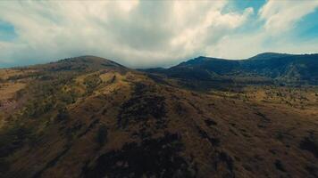 aéreo Visão do uma áspero montanha panorama debaixo uma dramático nublado céu. video