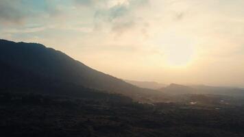 brumeux lever du soleil plus de une tranquille Montagne paysage avec doux lumière et en couches collines. video