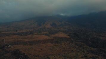 aérien vue de une vaste, de mauvaise humeur paysage avec une Montagne partiellement couvert par des nuages. video