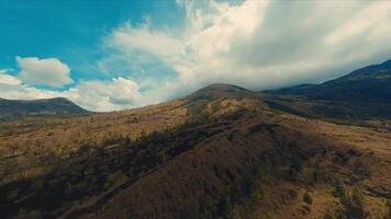 scénique vue de roulant collines en dessous de une spectaculaire nuageux ciel, mettant en valeur la nature immensité et tranquillité. video