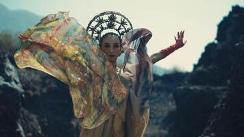 femme dans traditionnel robe et casque posant dans une rocheux paysage. video