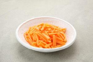 Fresh organic slice carrots on white plate grey background. photo