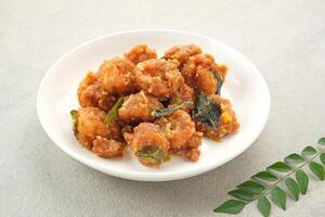 Salted egg fried shrimp or udang telur asin with curry leaves photo