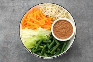 Pecel Sayur, Indonesian traditional salad, mix steamed vegetable with peanut sauce photo