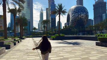 happy girl with long hair spins in the city with a view of high-rise buildings. High quality FullHD footage video