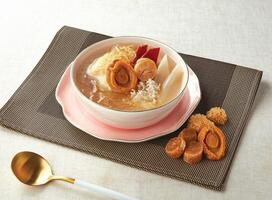 Claypot wings with abalone, scallops, golden legs and chicken served in a bowl isolated on napkin side view of hong kong food photo